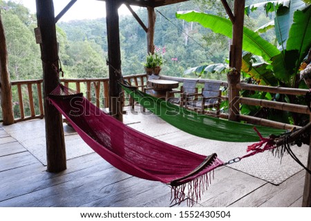 Hammock or cradle a sling made of fabric, rope, or netting, suspended between wooden pole in house for relaxing and sleeping in summer season.