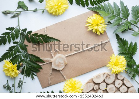 card mockup with chrysanthemums and envelope. wedding invitation in minimalist style with leaves