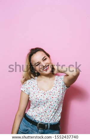 A portrait of young and cheerful blonde girl posing fashion on a pink background