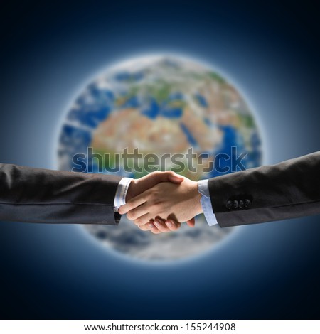 handshake of two businessmen on the background of the planet earth. Elements of this image are furnished by NASA