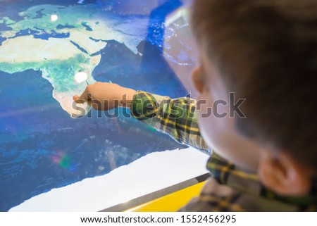 Child pointing Africa on a map.