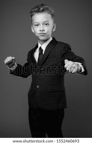Young boy as businessman wearing suit in black and white