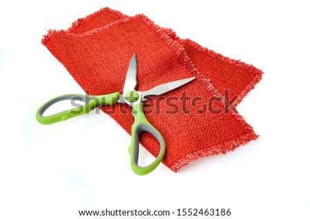 red fabric with scissors isolated on white background
