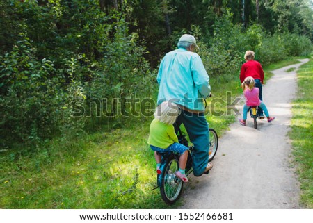 active senior granddad with kids riding bikes in nature