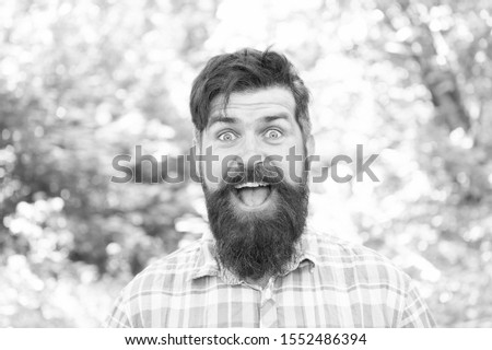 Being good spirits. Happy hipster on summer day. Bearded man smiling in trendy hipster style on natural environment. Brutal guy in casual hipster style. Hipster wearing thick beard and stylish hair.
