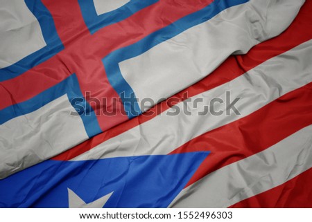 waving colorful flag of puerto rico and national flag of faroe islands. macro