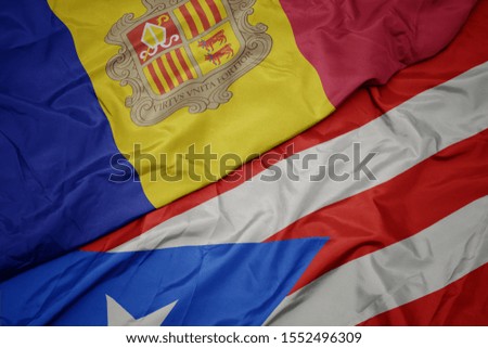 waving colorful flag of puerto rico and national flag of andorra. macro