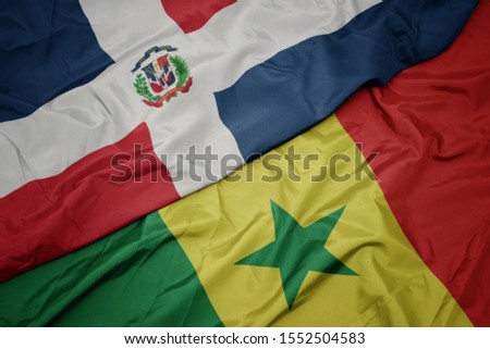 waving colorful flag of senegal and national flag of dominican republic. macro