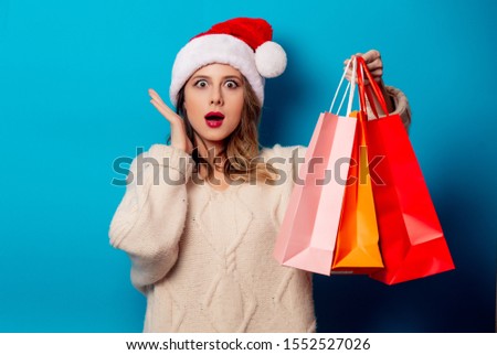 Beautiful woman with shopping bags on blue background