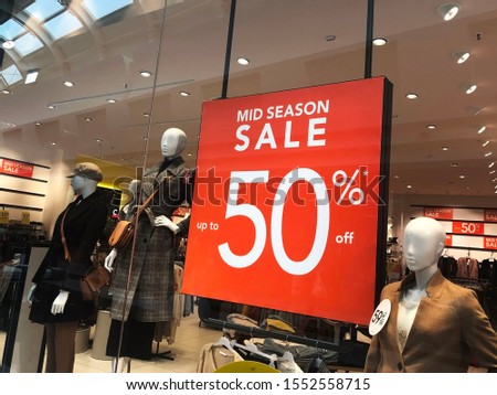 50% sales off board in clothes store. Female fashion store. Sales concept. Black friday.  Mannequins in window display