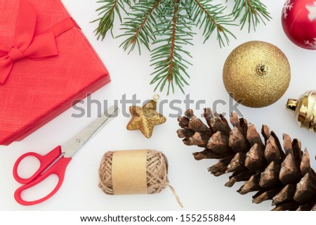 Creative Composition Useful for Christmas and New Year Greeting Card Created Using Decorative Balls, Pine Cones, Scissors,  Gift Box, Packthread and Green Pine Branch