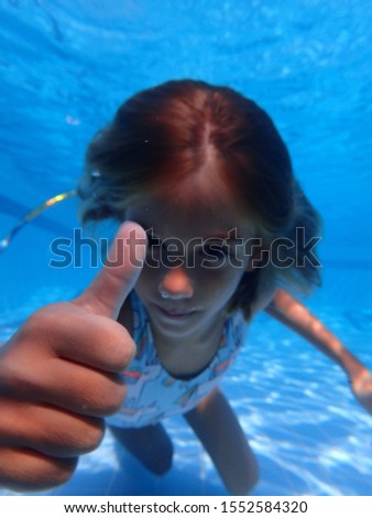 little girl happy and playing in the swimming pool 
