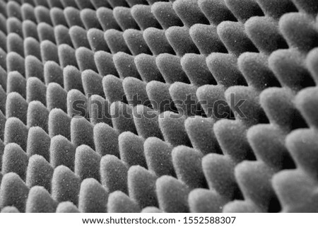 Dark artificial foam, acoustic foam insulation texture on background.