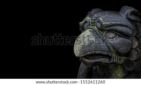 Banner of ancient statue of medieval griffin, a hybrid of lion and bird, covered with moss isolated at black background with paste space