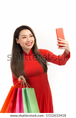 Beauty women wear aodai selfie while hold shopping bags in lunar new year