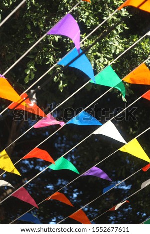 Colorful flags waving on wind, banners flap on breeze, decorative garlands floats in air, beautiful billowing flags lines above, flying triangular flags design element