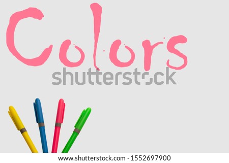 Colored markers on a white background, accompanied by the word color and with a fun design