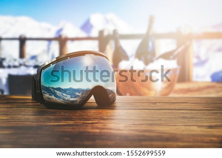 apres ski - goggles with mountains reflection on the restaurant table at ski resort Royalty-Free Stock Photo #1552699559