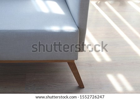 Close up detail of white fabric sofa with wood leg in living room Royalty-Free Stock Photo #1552726247