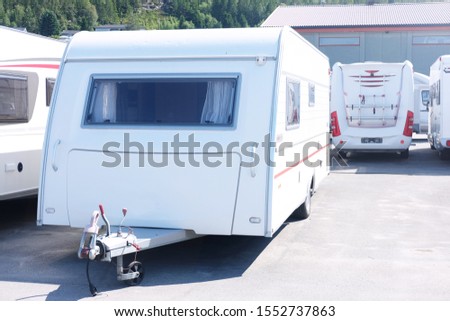 white trailer houses are in the parking lot, the theme of travel and tourism
