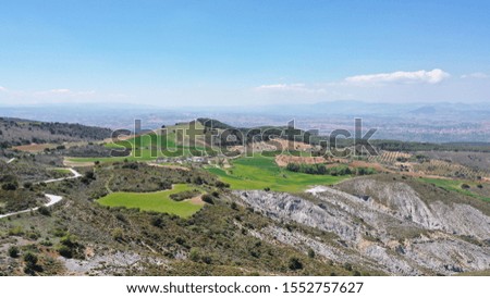 Autumn colors. Aerial view of very green mountainous landscape and clear sky.