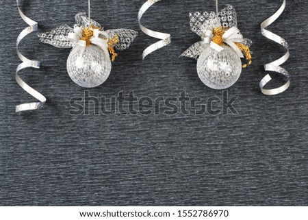 Beautiful Christmas card.Christmas shiny ball with bow and silver streamer on dark background