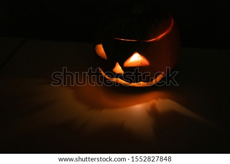 Alone head of the pumpkin inside the dark room. Only candle make a light during october halloween night.