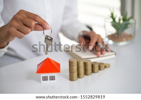 Real estate agent with house model and keys. Real estate investment.