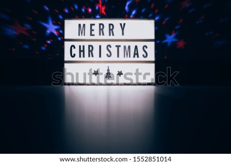 Merry christmas sign in lightbox in the dark room interior with space for text