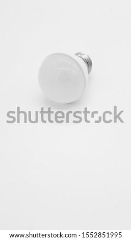 Close-up of a white energy saving compact fluorescent lightbulb or light bulb isolated on a white background. Concept of energy transition and renewable energies. 