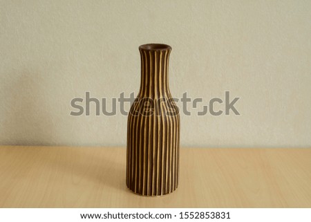 Flower vase on a table by the wall