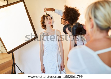 Make-up artist or makeup artist applying make-up to a bride in a photo studio