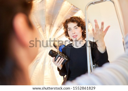 Photographer with medium format camera discusses with colleague in the photo studio