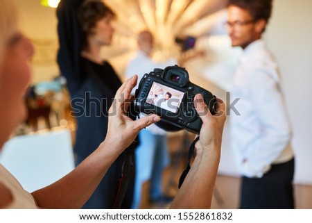 Photographer inspects portrait photo on the display of the digital camera