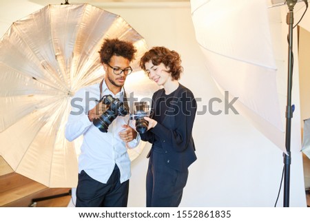 Photographers with digital and retro medium format camera in the photo studio