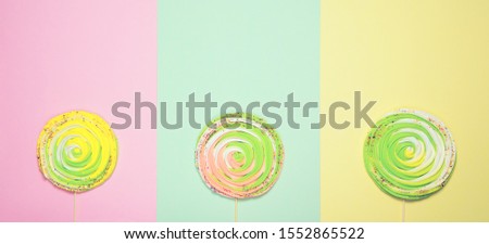 Colorful meringues on sticks on colorful pastel background. Festive and party concept. Minimal style. Flat lay. Top view