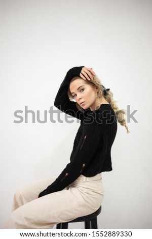 portrait of a girl sitting sideways in a sweater
