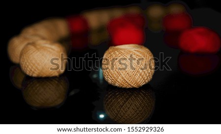 Brown and red weaving yarn balls on a glass surface