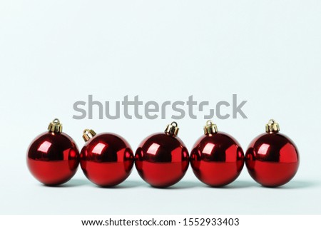 Red christmas balls in a row on a blue background. Place for text.