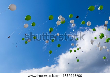 Balloons in green and white flying up into the sky
