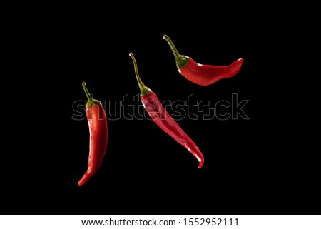 Three Red Chili Peppers Isolated On Black Background