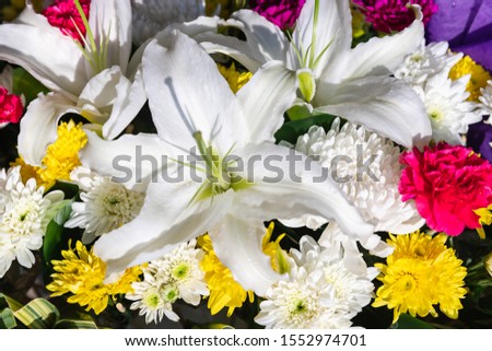 Close up of white lily flowers ,carnation, chrysanthemum flowers and green leaves ,at Pak Khlong Talat flower market, Thailand.