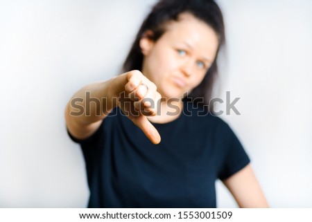 beautiful girl shows thumb down isolated on white background