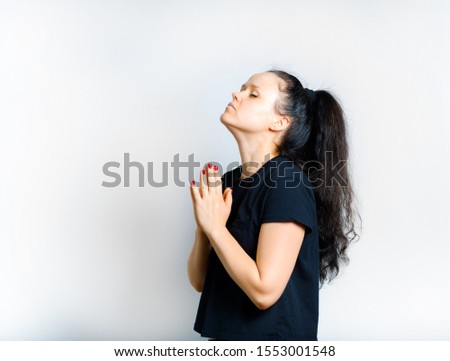 beautiful girl with dark long hair prays isolated on a white background