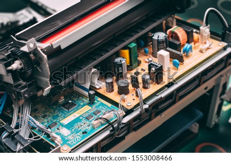 Photo of an open laser printer showing its internal components and circuitry. The motherboard, drum and photoconductor unit are visible. Royalty-Free Stock Photo #1553008466