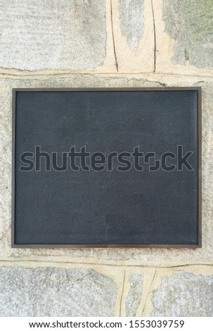 Blank Black Slate Plaque on a Stone Boulder Wall