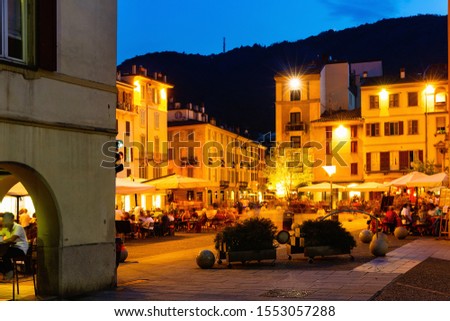 The streets and buildings of Como city in evening near mountains in Italy