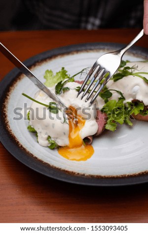 In a plate of bruschetta, ham, on it a mix of salad and poached egg
