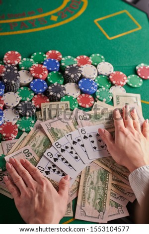 casino background, straight flush cards at the player and dollars and chips on the poker table. Gaming business, success. Vertical frame.