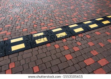Speed bump on the road. Speed limiter on the road from a stone blocks.